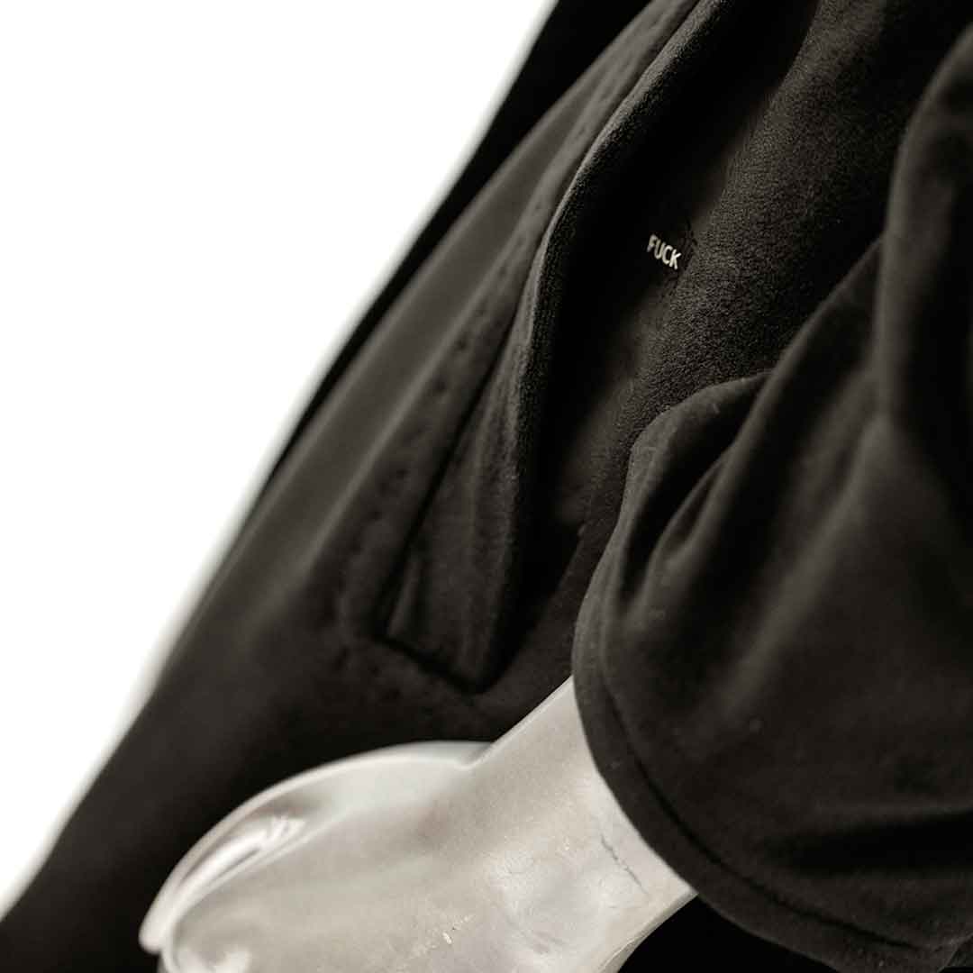 pocket of black velvet hoodie coat suit jacket on form over white background
