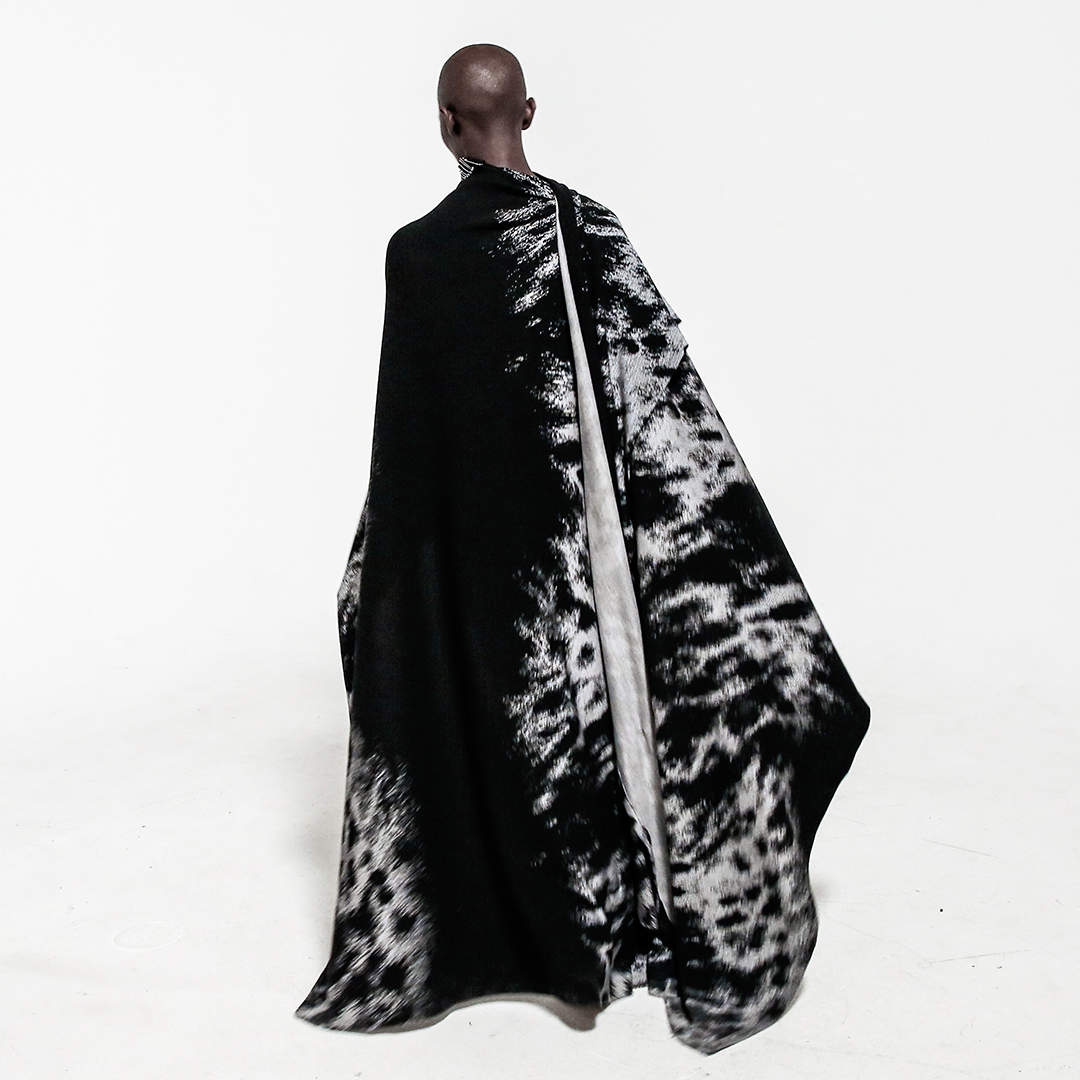 back view model in safety pin cape over white background